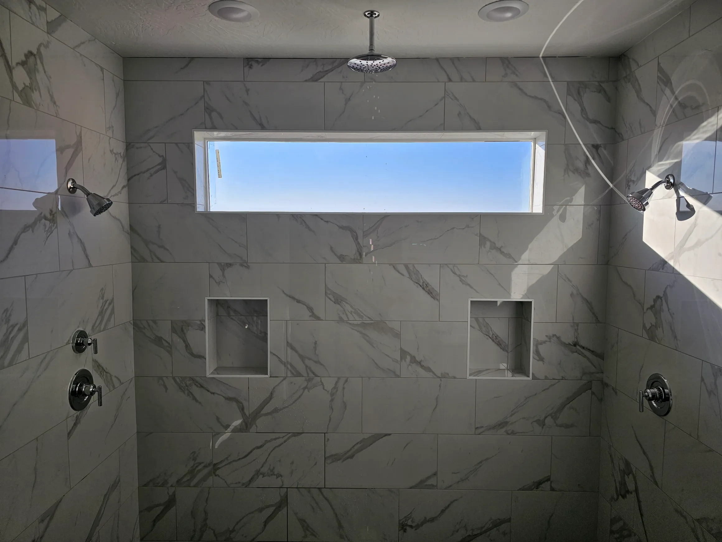 Beautifully finished dual shower with skylight — completed by Copper Bear Plumbing